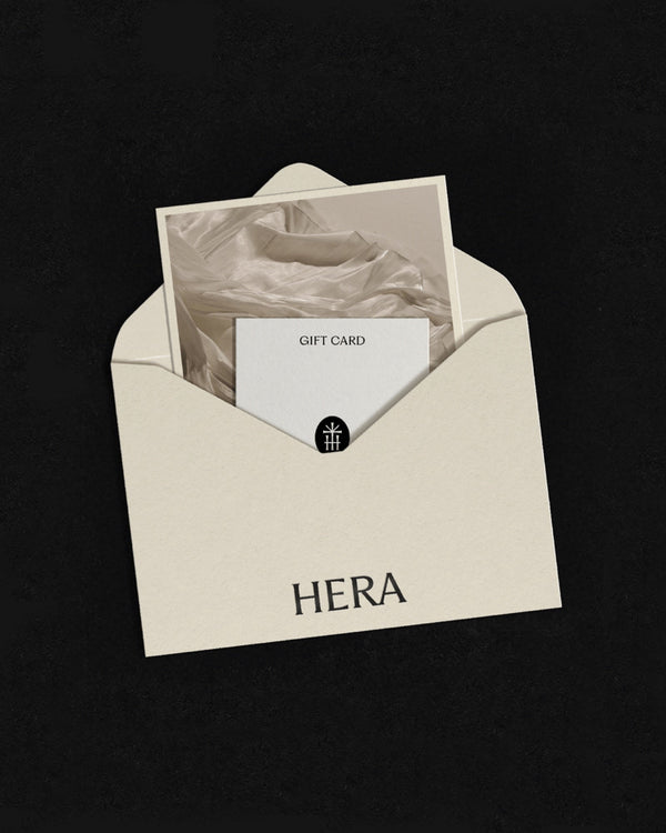 A Hera gift card in a cream envelope on a dark background